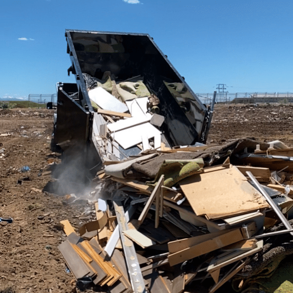 Homeowner safely using roll-off dumpster for junk removal