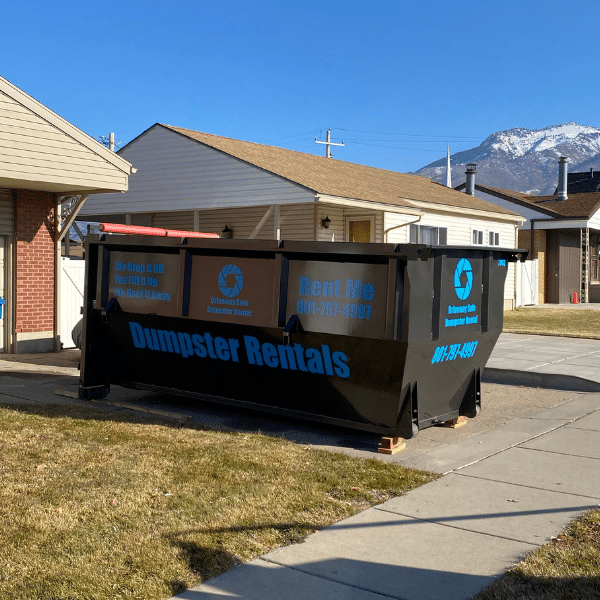 Dumpster placed safely on wood blocks to protect driveway